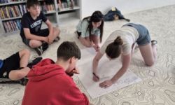 sala w bibliotece, zebrana młodzież siedzi na krzesełkach,