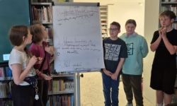 sala w bibliotece, zebrana młodzież siedzi na krzesełkach,