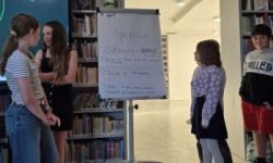 sala w bibliotece, zebrana młodzież siedzi na krzesełkach,