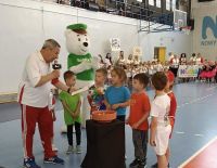 hala sportowa, dzieci w kolorowych strojach sportowych, dzieci na trybunach