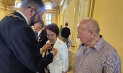 sala balowa w kasynie oficerskim, burmistrz przypina medale małżeństwom, wspólne zdjęcie