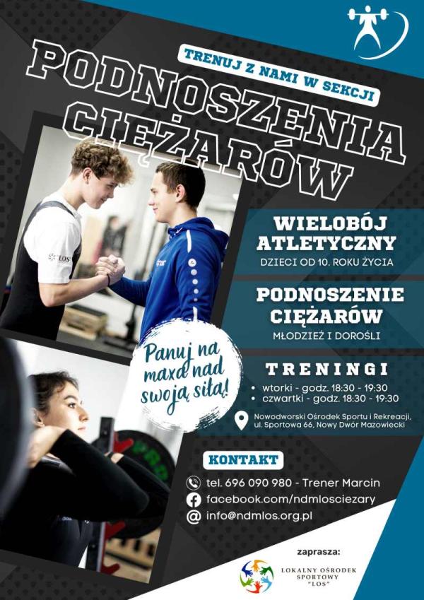 Chłopiec z w białej koszulce i czarnym kostiumie do podnoszenia ciężarów, drugi w niebieskiej bluzie dresowej z białymi wzorami na rękawie, patrzą na siebie, mając złączone prawe dłonie. Dziewczyna ze sztaga na wysokości górnej części klatki piersiowej.