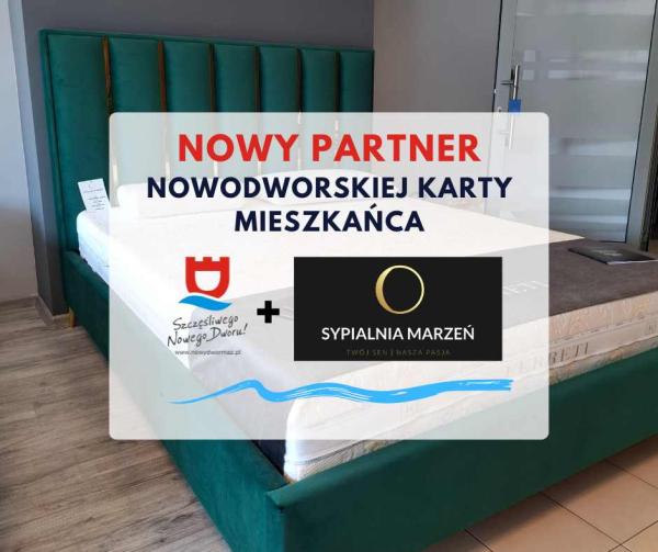 Zielone łóżko w sypialni z grubym beżowym materacem.