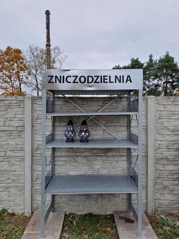Dwa znicze na regale z napisem zniczodzielnia.