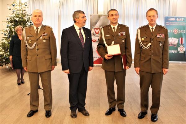Trzech mężczyzn w mundurach wojskowych i jeden w garniturze.