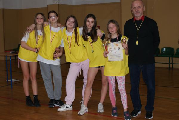 Cztery dziewczynki z medalami obejmują się wzajemnie za ramiona. Piąta trzyma puchar, dyplom i statuetkę z piłkarzem.