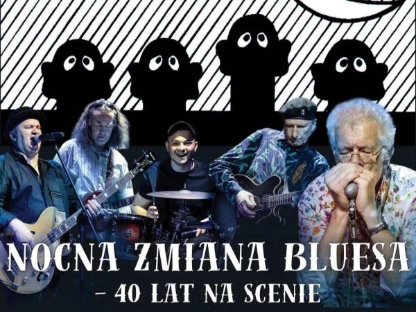 Pięciu mężczyzn: jeden grający na harmonijce, drugi na perkusji i trzech na gitarach.