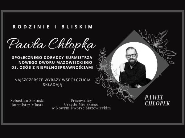 Mężczyzna w okularach z brodą i wąsami z lewą dłonią na prawym ramieniu.