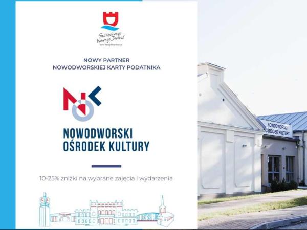 Biały zabytkowy budynek z szarym, blaszanym dachem.