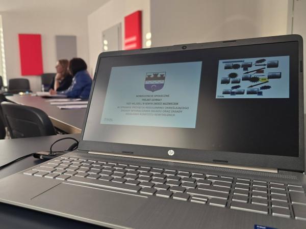 Laptop z wyświetlaną na spotkaniu prezentacją