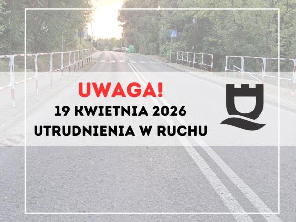 Ulica z chodnikami i barierkami po obu stronach.